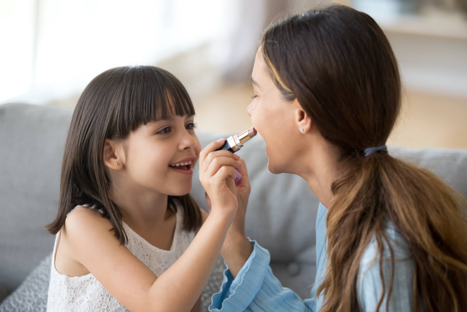 Little Girl Applying Lipstick to Mother